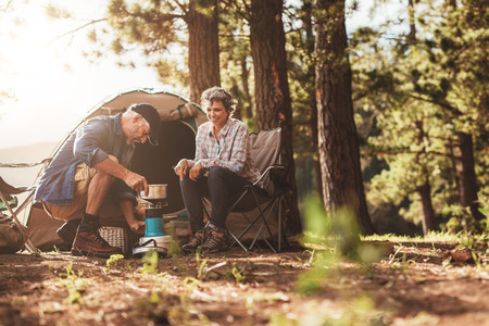 man pouring coffee at campsite